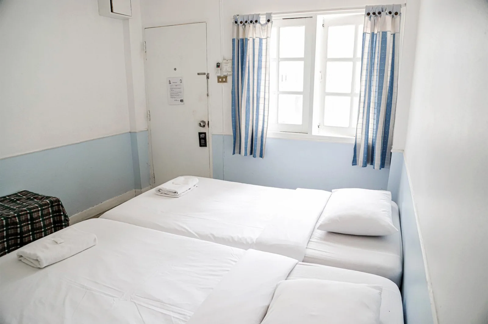 Guest room with a soft blue accent wall and twin beds