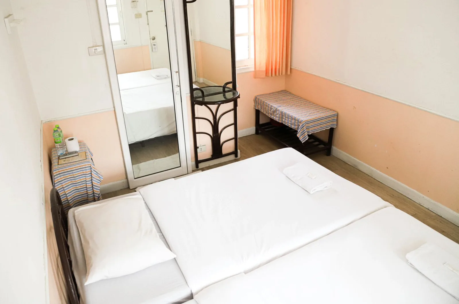 Standard room with a warm peach accent wall and en-suite bathroom